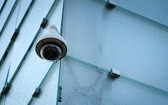 Video surveillance camera on modern glass facade.