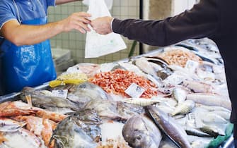 Italy, Veneto, Venice, man buying fish from market seller
