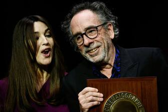 US director Tim Burton (R) receives the Lumiere Award from Italian actress Monica Bellucci during the award ceremony of the 14th edition of the Lumiere Film Festival in Lyon, central-eastern France, on October 21, 2022. (Photo by JEFF PACHOUD / AFP) (Photo by JEFF PACHOUD/AFP via Getty Images)