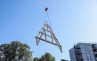 epa10739068 A wood framework is transported with a crane to the construction site of Notre Dame Cathedral in Paris, France, 11 July 2023. The oak trusses of the framework are 14 to 16 metres wide and 12 to 13 metres high and weigh between 7 and 7.5 tons, and are the main framework for the Cathedral's spire. Since the fire which devastated the cathedral on 15 April 2019, hundreds of people are working on its reconstruction with the target to reopen the Cathedral before the end of 2024.  EPA/TERESA SUAREZ