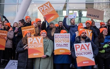 LONDON, UNITED KINGDOM - 2023/12/20: Protesters hold placards and shout slogans outside the University College Hospital in London, UK. BMA (British Medical Association) says the junior doctors' pay has been cut by more than a quarter since 2008/9. Because of that they strike for full pay restoration. (Photo by Krisztian Elek/SOPA Images/LightRocket via Getty Images)