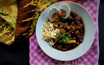 Rawon or Nasi Rawon/Rawon Rice is traditional Indonesian beef black soup served with sprouts, salted eggs, kluwek seasoning. From east java. Isolated