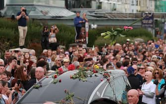 Fans of singer Sinead O'Connor line the streets for a "last goodbye" to the Irish singer as her funeral cortege passes through her former hometown of Bray, Co Wicklow, ahead of a private burial service. Picture date: Tuesday August 8, 2023.