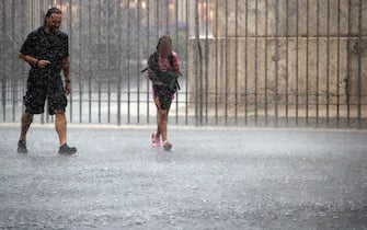 Turisti si riparano dalla pioggia per il temporale abbattutosi sulla Capitale, Roma, 03 settembre 2024. ANSA/ANGELO CARCONI