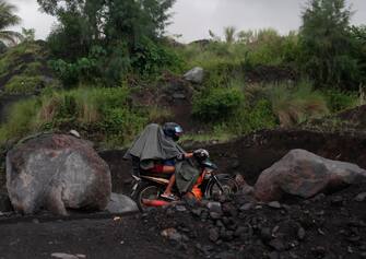 epa10684715 Villagers living at Mayon volcano s danger zone ride on a motorcycle during a mass evacuation in Daraga, Albay province, Philippines, 11 June 2023. The province of Albay was placed under a state of calamity due to the threat of an eruption of Mayon Volcano. The office of Civil Defense had evacuated 2,638 families in the towns of Camalig, Ligao City, Daraga, Guinobatan, Malilipot and Tabaco City.  EPA/FRANCIS R. MALASIG