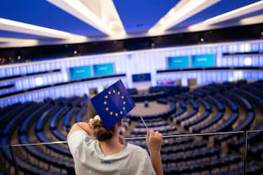 TOPSHOT - A person holds an EU flag at the European Parliament building, during an election evening in Strasbourg, on June 9, 2024, after the vote for the European Parliament election. (Photo by SEBASTIEN BOZON / AFP) (Photo by SEBASTIEN BOZON/AFP via Getty Images)