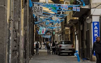 Naples, Italy - April 2, 2023: Flags, bunting and streamers stretched across the Via San Giuseppe dei Ruffi in the Centro Storico district in the cent