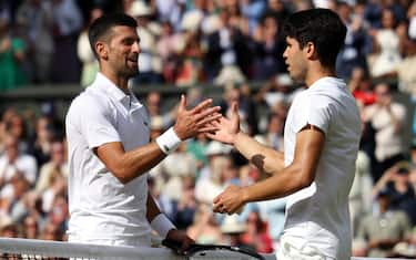 epa11477778 Carlos Alcaraz of Spain (R) shakes hands with Novak Djokovic of Serbia after winning the Men's final at the Wimbledon Championships, Wimbledon, Britain, 14 July 2024.  EPA/NEIL HALL  EDITORIAL USE ONLY