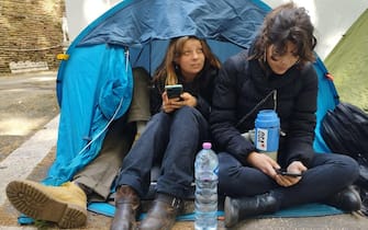 Alcuni studenti dentro una tenda da campeggio hanno montato dei cartelli di protesta contro il caro affitti  davanti al Mur a Roma, 11 maggio 2023.
ANSA/Cecilia Ferrara