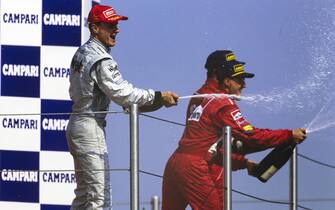 IMOLA, ITALY - APRIL 26: David Coulthard, 1st position, Michael Schumacher, 2nd position, and Eddie Irvine, 3rd position, spray champagne on the podium during the San Marino GP at Imola on April 26, 1998 in Imola, Italy. (Photo by LAT Images)
