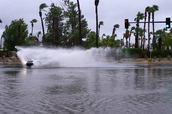 epa10811211 A car moves through flooded water as Tropical Storm Hilary arrives in Cathedral City, California, USA, 20 August 2023. Southern California is under a tropical storm warning for the first time in history as Hilary makes landfall. The last time a tropical storm made landfall in Southern California was 15 September 1939, according to the National Weather Service.  EPA/ALLISON DINNER