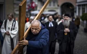epa12039084 Believers walk through the streets of Zurich during a Way of the Cross procession on Good Friday in Zurich, Switzerland, 18 April 2025. The ecumenical Way of the Cross procession, involving believers of different confessions, is taking place for the 29th time and visits several Way Stations in Zurich.  EPA/MICHAEL BUHOLZER