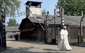 Papa Francesco ad Auschwitz TOPSHOT - Pope Francis walks through the entrance of the former Nazi death camp of Auschwitz in Oswiecim on 29 July, 2016. - Pope Francis visits the Auschwitz-Birkenau WWII-era Nazi German death camp where he will pray with Poland's chief Rabbi Michael Schudrich for its 1.1 million victims and meet with Holocaust survivors. (Photo by JANEK SKARZYNSKI / AFP) (Photo by JANEK SKARZYNSKI/AFP via Getty Images)