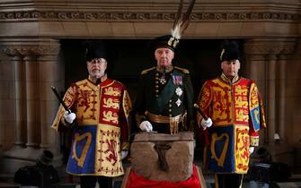 The Duke of Buccleuch Richard Scott (C), flanked by two Officers of Arms, stands by the Stone of Destiny during a special ceremony at Edinburgh Castle on April 27, 2023 before it is transported to Westminster Abbey for the Coronation of Britain's King Charles III. - The Stone of Destiny, a sacred slab of sandstone that became a symbol of Scottish nationhood, left Edinburgh Castle for London, where it will play a key role in King Charles III's coronation. The 152-kilogram (335-pound) stone, seized from the Scots by the king of England Edward I in 1296, is being taken to Westminster Abbey in London for the May 6 ceremony. (Photo by RUSSELL CHEYNE / POOL / AFP) (Photo by RUSSELL CHEYNE/POOL/AFP via Getty Images)