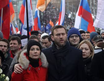 MOSCOW, RUSSIA - FEBRUARY 27: (RUSSIA OUT) Russian opposition leader Alexei Navalny (C) embraces his spouse Yulia Navalnaya (L) attend a mass march marking the one-year anniversary of the killing of opposition leader Boris Nemtsov on February 27, 2016 in Moscow, Russia. Several thousand people held a march in Moscow in memory of the Russian opposition leader to mark the first anniversary of his killing. (Photo by Mikhail Svetlov/Getty Images)