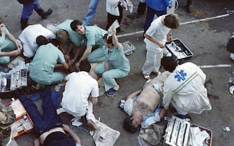 Rescuers attend victims on May 29, 1985 after 39 people lost their lives and more than 600 others were injured in violent incidents inside the stadium, an hour before the kick off of the European Champion Clubs final between Britain's Liverpool and Italy's Juventus of Turin at Heysel stadium. The tragedy occured when a wall collapsed in the stadium under the pressure of people and crushed Juventus fans as they tried to escape Liverpool supporters. (Photo by DOMINIQUE FAGET / AFP) (Photo by DOMINIQUE FAGET/AFP via Getty Images)