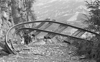 A twisted railroad track rises from the rubble, Longarone, near the Vajont Dam in the Piave Valley, Italy, early October, 1963. On October 9, a landslide in the dam basin caused a wave more than 800 feet high to overtop the dam and flood the valley below--five villages were completely destroyed, more than 2000 people were killed, and thousands more were left homeless and displaced. (Photo by Archivio Cameraphoto Epoche/Getty Images)