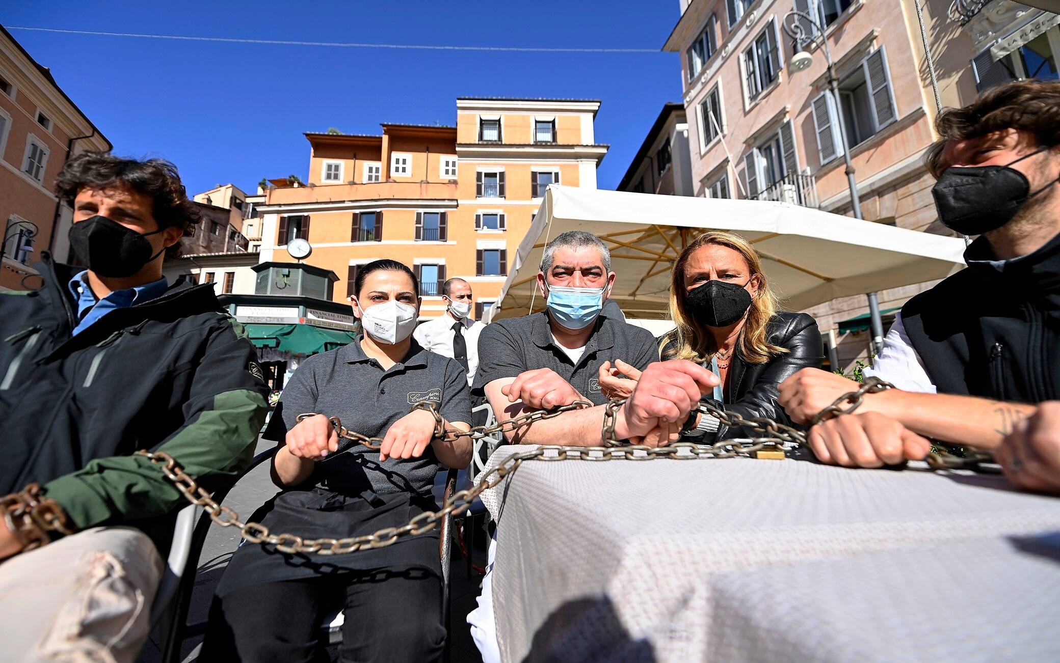 La protesta dei ristoratori e dei lavoratori dei bar incatenati ai tavolini