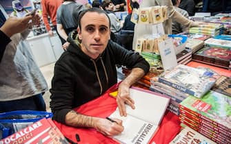 NO FRANCE - NO SWITZERLAND: December 9, 2017 : Zerocalcare (zerolimestone- Michele Rech) Italian cartoonist signs a dedication on the books to his readers during the national fair of small and medium publishing, at the La Nuvola (the cloud) convention center in Rome.