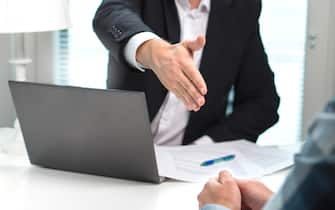 Business man offer and give hand for handshake in office. Successful job interview. Apply for loan in bank. Salesman, bank worker or lawyer.