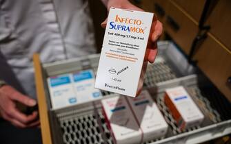 03 May 2023, Saxony, Leipzig: A pharmacist takes a pack of InfectoSupramox, an antiobiotic with the active ingredient amoxicillin, from a drawer. The Federal Association of German Pharmacists (ABDA) has criticized politicians in view of the shortages of medicines. Photo: Jan Woitas/dpa (Photo by Jan Woitas/picture alliance via Getty Images)