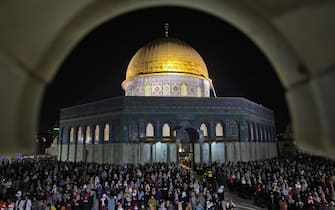 TOPSHOT - Palestinian devotees pray on Laylat al-Qadr (Night of Destiny) outside the Dome of the Rock in Jerusalem's Al-Aqsa Mosque compound during the Muslim holy month of Ramadan on May 8, 2021. (Photo by ahmad gharabli / AFP) (Photo by AHMAD GHARABLI/AFP via Getty Images)