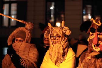 epa11040201 People wearing costumes and masks participate in a winter solstice celebration event in Riga, Latvia, 21 December 2023. One of the ancient traditions associated with Latvian Christmas is the rolling of the Yule log. At the end of the procession, the Yule log is burned in a bonfire in honor of the Sun, symbolizing the beginning of a new solar year. According to custom, the ancient ritual can be understood as a collection and burning of all difficulties and misfortunes of the past year.  EPA/TOMS KALNINS