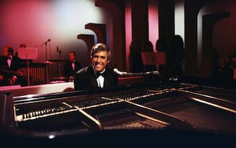 LOS ANGELES, CA - 1968:  American singer and pianist Burt Bacharach performs with his piano circa 1968 in Los Angeles, California.  (Photo by Martin Mills/Getty Images)