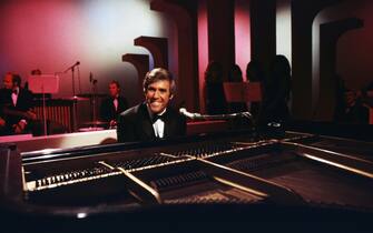 LOS ANGELES, CA - 1968:  American singer and pianist Burt Bacharach performs with his piano circa 1968 in Los Angeles, California.  (Photo by Martin Mills/Getty Images)