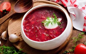Borscht soup in white bowl with sour cream. National Ukrainian and Russian cuisine food. Closeup view