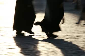 shadow of priests walking in street in rome, italy