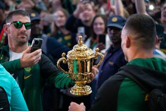 epa10950304 Springbok rugby team player Willie le Roux (L) poses with the William Webb Ellis Cup upon the team's arrival in the country after winning the 2023 Rugby World Cup, in Johannesburg, South Africa, 31 October 2023. The Springboks won back to back Rugby World Cups and are the only team to have won four titles. They will embark on a trophy tour around the country starting 02 November.  EPA/KIM LUDBROOK