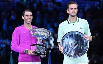 epa09718390 Rafael Nadal of Spain (L) holds the Norman Brookes Challenge Cup after winning the menÂ?s singles final against Daniil Medvedev of Russia (R, with his runner-up trophy) at the Australian Open grand slam tennis tournament at Melbourne Park in Melbourne, Australia, 30 January 2022.  EPA/DEAN LEWINS AUSTRALIA AND NEW ZEALAND OUT