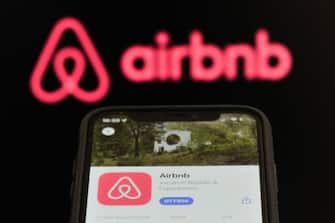 An Airbnb download app page displayed on a smartphone and an Airbnb logo displayed on a personal computer are seen in L'Aquila, Italy, on september 9th, 2023. Some metropolises and countries are imposing restrictions on Airbnb hosts to protect the hotel industry. (Photo by Lorenzo Di Cola/NurPhoto via Getty Images)