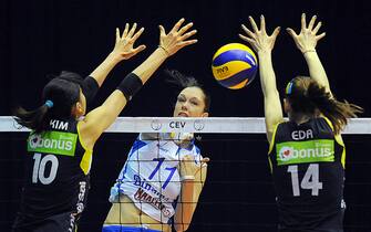 Dinamo Kazan's Ekaterina Gamova (C) spikes the ball over Fenerbahce Universal's Yeon-Koung Kim (L) and Eda Erdem (R) during the Final four of their 2012 CEV Volleyball Champions League women semi-final match in Baku on March 24, 2012. AFP PHOTO / VANO SHLAMOV     (Photo credit should read VANO SHLAMOV/AFP via Getty Images)