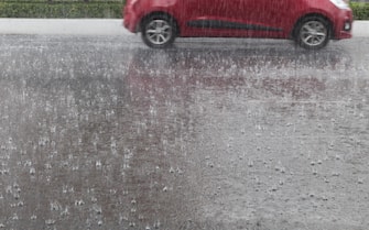Heavy rain on the street, car driving in the background