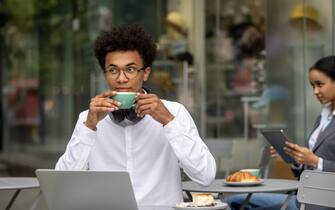 Un ragazzo lavora in smart working da un bar
