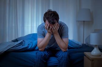 Depressed man at night feeling alone and useless