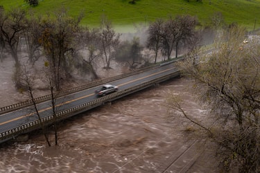SPRINGVVILLE, CA - MARCH 10: In an aerial view, a pickup truck crosses a bridge over the flooding Tule River on March 10, 2023 near Springville, California. Another in a series of atmospheric river storms from the Pacific Ocean has brought a warm rain to the region, which is falling on top of, and melting, large areas of snow in the Sierra Nevada Mountains, increasing the risk of floods at lower elevations. This years  destructive and deadly storms have produced heavy rains and a near-record snowpack in the Sierras, which provides water for millions of Californians. As a result of one of Californias wettest winters on record, most of the state has gotten relief from years of drought. (Photo by David McNew/Getty Images)