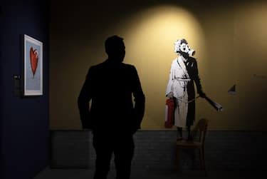 epa10485407 A man looks at a graffiti that forms part of the exhibition 'The Mystery of Banksy' on dislpay at the Halle 622 in Zurich, Switzerland, 23 February 2023. The exhibition featuring replicas of works by British anonymous street artist Banksy runs from 24 February to 31 May 2023.  EPA/MICHAEL BUHOLZER