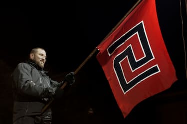 ATHENS, GREECE - FEBRUARY 1: Supporter of ultra nationalist party Golden Dawn hold party flag  as they demonstrate on February 1, 2014 in Athens, Greece. Members of the far right party Golden Dawn protest against the indictment of several Golden Dawn members and their leader Nikos Michaloliakos in a government crackdown. . (Photo by Milos Bicanski/ Getty Images)