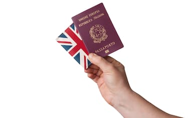 Man hold a european union italian passport and a united kingdom flag wallet on white background