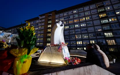 People pray in front of the statue of John Paul II at the entrance to the Gemelli Hospital, where Pope Francis is hospitalized, in Rome, Italy, 6 March 2025. ANSA/FABIO FRUSTACI