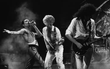British rock group Queen in concert, from left to right; Freddie Mercury (Frederick Bulsara, 1946 - 1991), John Deacon, and Brian May.  Original Publication: People Disc - HU0463   (Photo by Express Newspapers/Getty Images)