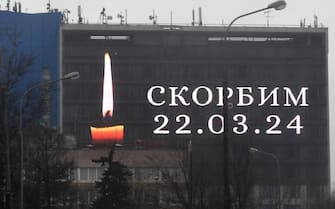 An advertising screen on the facade of a building displays an image of a lit candle and the slogan "(We) Mourn" in memory of victims of the concert hall gun attack in Moscow on March 23, 2024. Gunmen who opened fire at a Moscow concert hall killed more than 60 people and wounded over 100 while sparking an inferno, authorities said on March 23, 2024, with the Islamic State group claiming responsibility. (Photo by Olga MALTSEVA / AFP) (Photo by OLGA MALTSEVA/AFP via Getty Images)