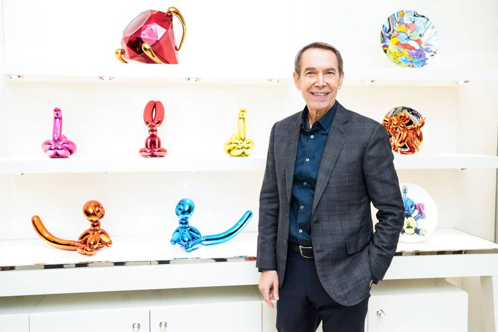 Jeff Koons accanto ad alcune delle sue opere