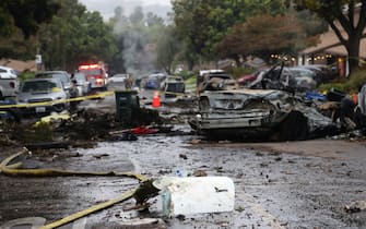 A street is littered with debris where a small plane crashed  into San Diego, California, residential street on May 22, 2025. The Federal Aviation Authority said a Cessna 550 crashed at around 3:45 am local time. The neighborhood is close to the Montgomery-Gibbs Executive Airport. The crash left a "gigantic debris field" and damaged some 15 homes and parked cars, ABC News quoted the San Diego assistant fire chief as saying. (Photo by Sandy Huffaker / AFP)