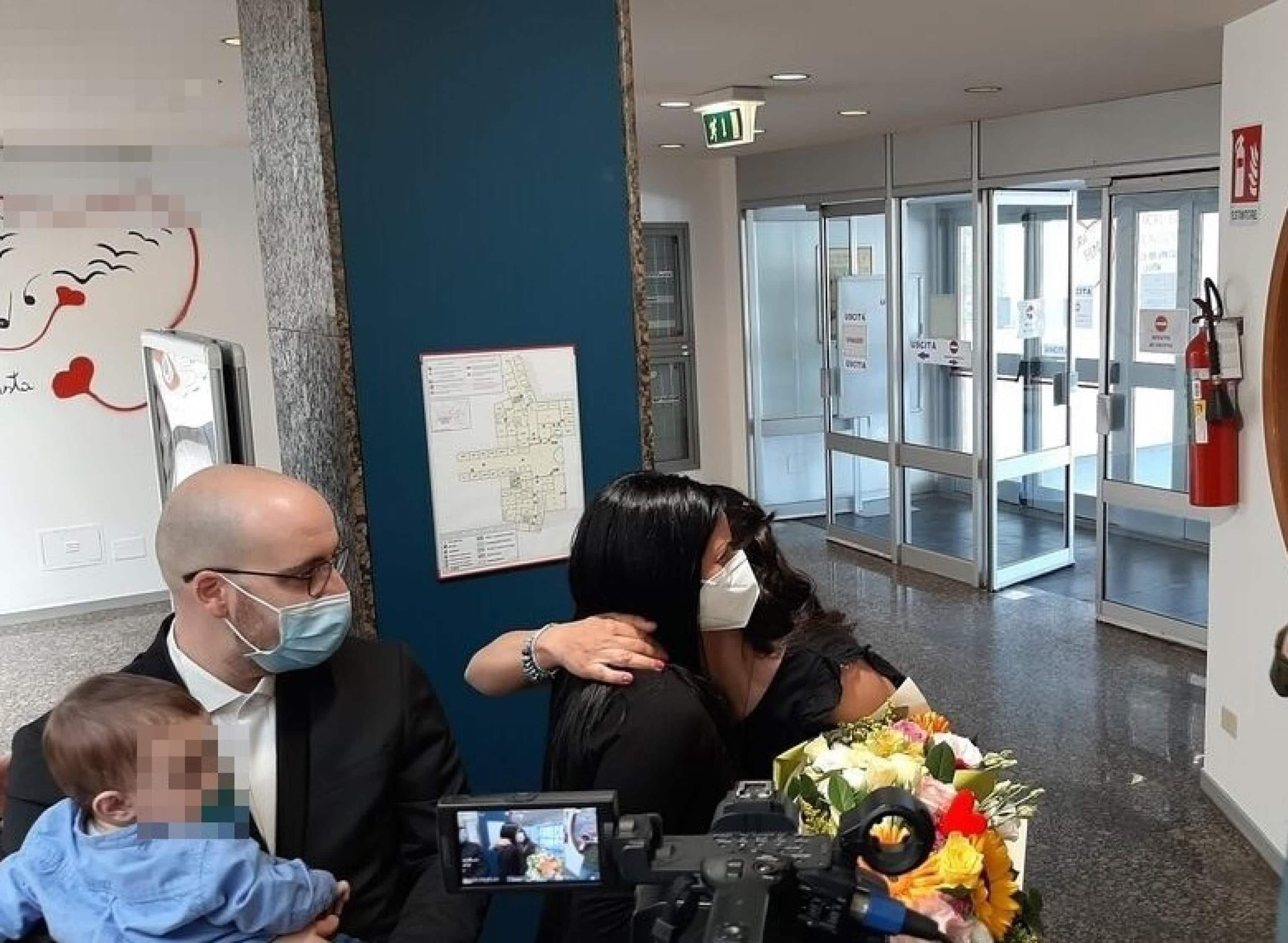 Un momento della cerimonia, svoltasi agli Ospedali Riuniti, per ricordare la vicenda del bimbo ricoverato a marzo per Covid all'ospedale materno infantile 'Salesi' di Ancona, che era era stata immortalata in una foto divenuta virale sul web: lo scatto ritraeva il piccino sul letto in Rianimazione Pediatrica, con accanto l'infermiera Katia Sandroni, bardata in tuta anti-contagio, che lo accarezzava tenendogli il ciuccio, Ancona, 31 maggio 2021. Un simbolo dell'impegno e dell'umanità degli operatori sanitari che da oltre un anno sono impegnati nella lotta contro la pandemia. Oggi i genitori del bimbo, Roberta ed Enrico, insieme al figlio, hanno partecipato con gratitudine alla cerimonia: per ricordare questa vicenda una targa è stata apposta all'ingresso del vecchio ingresso. Per la prima volta hanno incontrato di persona l'infermiera Katia: abbracci e lacrime di gioia per una "storia a lieto fine".
ANSA/ DANIELE CAROTTI