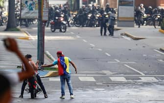 epa11507658 Two demonstrators take photographs during clashes between protesters and members of the Bolivarian National Guard (GNB) over the results of the presidential elections in Caracas, Venezuela, 29 July 2024. Protests are taking place in Caracas after the National Electoral Council (CNE) proclaimed that Nicolas Maduro was re-elected president of Venezuela, following elections held on 28 July.  EPA/Henry Chirinos