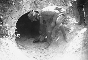 (Original Caption) Rome: Body Of Matteotti, Slain Deputy, Is Found. The body of Deputy Matteotti, a member of the Italian Chamber whose disappearance several months ago nearly resulted in the overthrow of the Mussolini government, has been found by a searching party in a fox's cave about 15 miles from Rome. Bloodhounds followed the scent traces to the mouth of the cave where the coat of the missing man was found. Inside the cave was found the shredded remains of the body which evidently had been bitten to pieces by the animals in the cave. One of the searching party is shown at the mouth of the cave, where the coat was found.